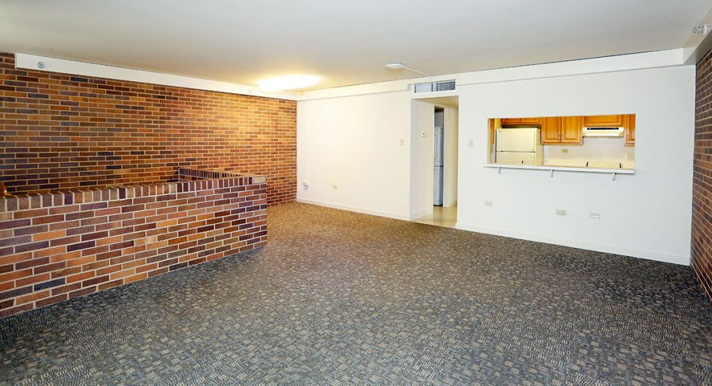 A photo of a living and dining area in University Manor East at Penn State College of Medicine shows an open area leading in from the kitchen with a counter or bar visible between the rooms.